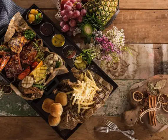 Un plateau de dégustation de viandes, poissons et fruits et une bouteille de vin au restaurant La Table de 3 à Bordeaux