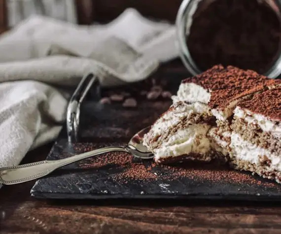 Des parts de tiramisu découpées avec une petite cuillère sur un plateau au restaurant La Table de Trois à Bordeaux